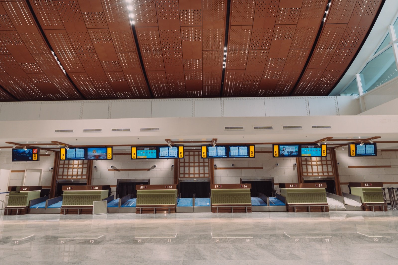 Row of check-in counters under the terminal’s patterned ceiling